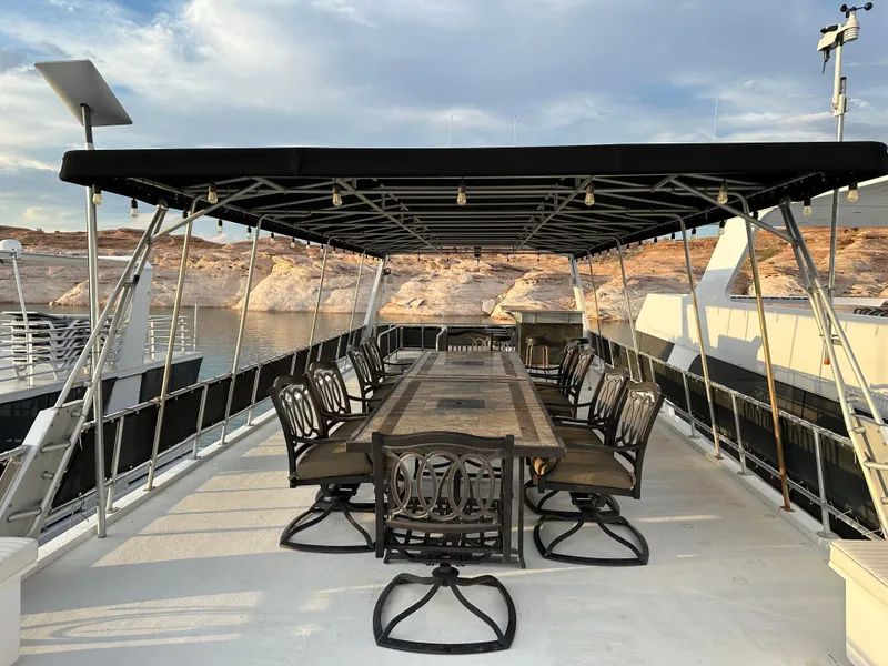 Slide: The Image of Spacious deck of 2001 Custom Endless Summer boat with elegant dining setup. - 17