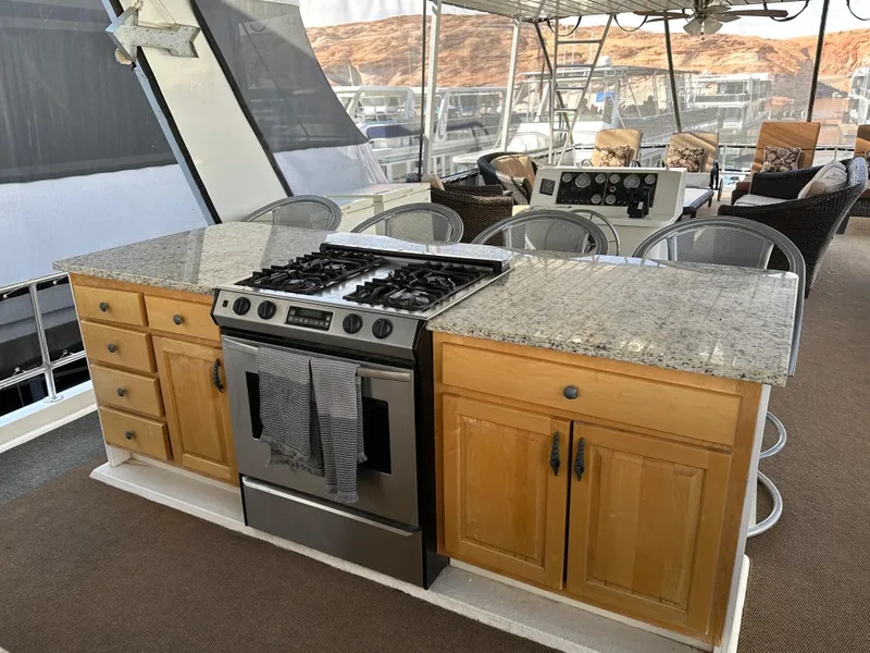 Slide: The Image of Granite countertop kitchen on 2001 Custom Endless Summer boat with stove and seating. - 30