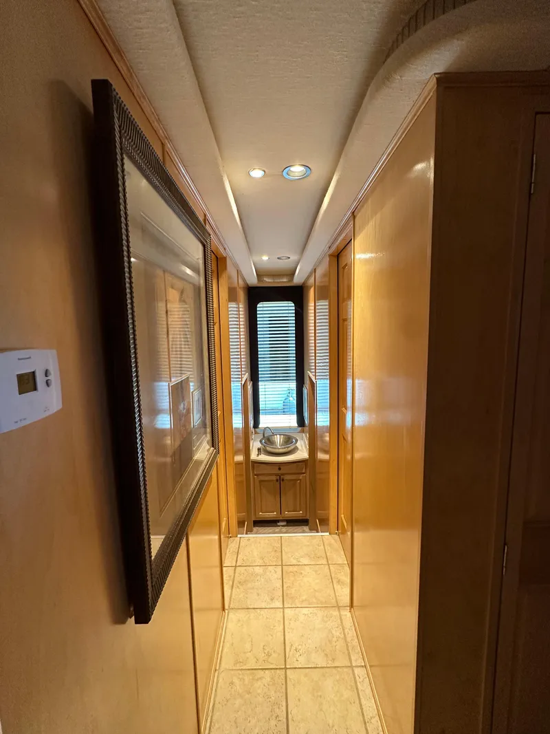 Slide: The Image of Narrow hallway in 2001 Custom Endless Summer RV with wood paneling and tiled floor. - 34