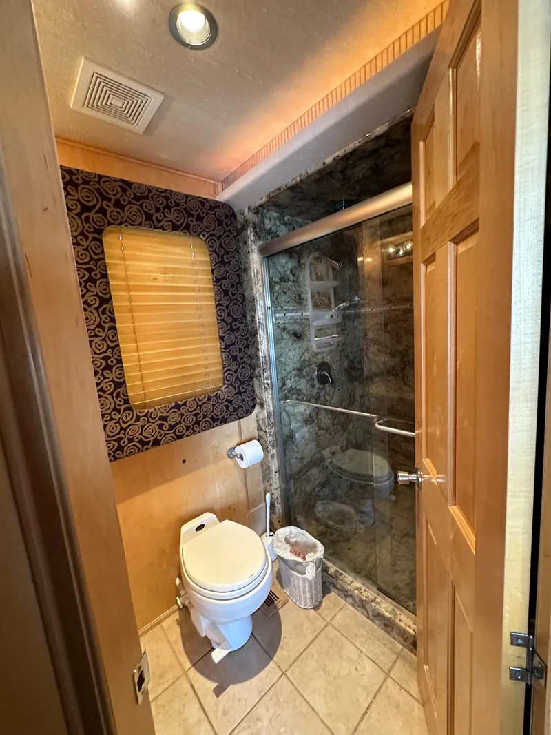 Slide: The Image of Luxurious RV bathroom with shower, toilet, and elegant decor in a 2001 Custom Endless Summer model. - 38