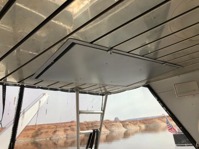 Slide: The Image of Interior view of 2001 Custom Endless Summer boat with ladder and scenic water backdrop. - 6