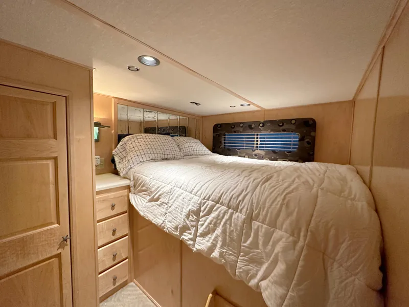 Slide: The Image of Cozy bedroom in 2001 Custom Endless Summer RV with wood paneling and built-in storage. - 9