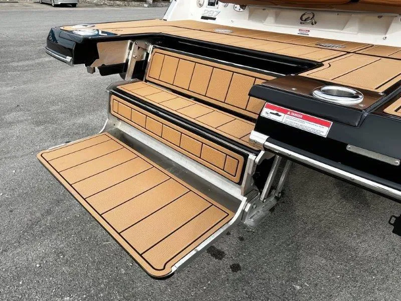 Slide: The Image of Chaparral 287 SSX 2025 boat swim platform with tan decking and cup holders. - 18