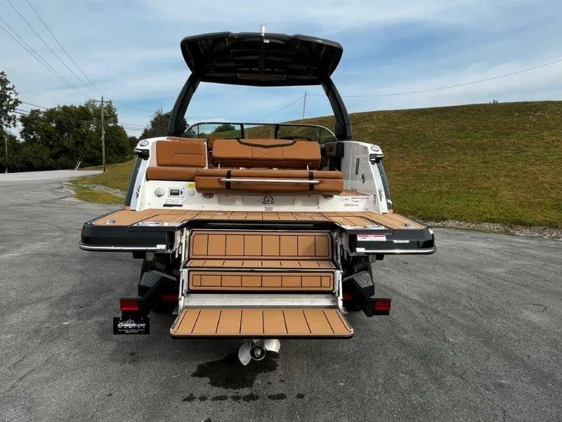 Slide: The Image of 2025 Chaparral 287 SSX boat with extended swim platform and seating, parked on pavement. - 20