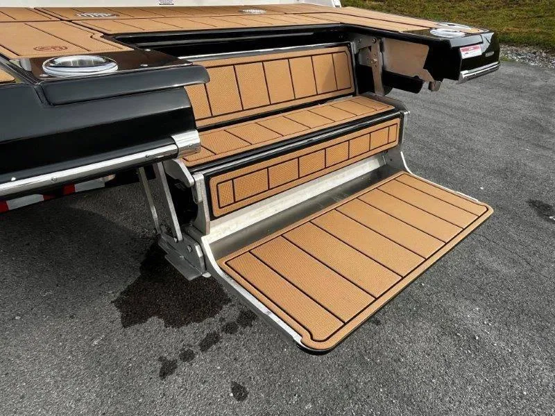 Slide: The Image of 2025 Chaparral 287 SSX boat swim platform with tan decking and fold-out steps. - 21