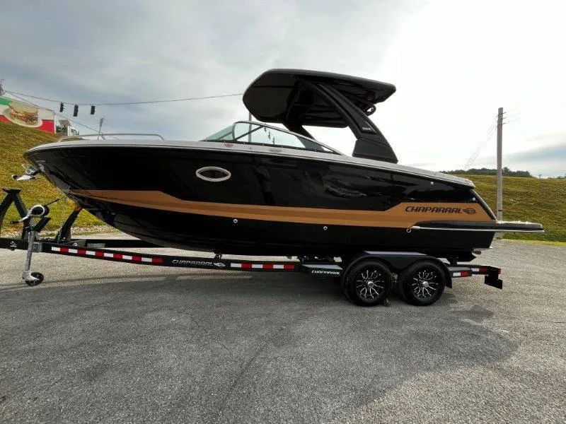 Slide: The Image of 2025 Chaparral 287 SSX boat on trailer, sleek black and brown design. - 25