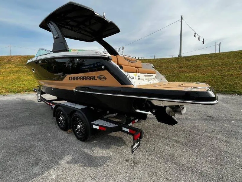 Slide: The Image of 2025 Chaparral 287 SSX boat on trailer, sleek design, black and tan exterior. - 26
