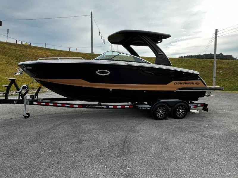 Slide: The Image of 2025 Chaparral 287 SSX boat on trailer, sleek black and tan design. - 29