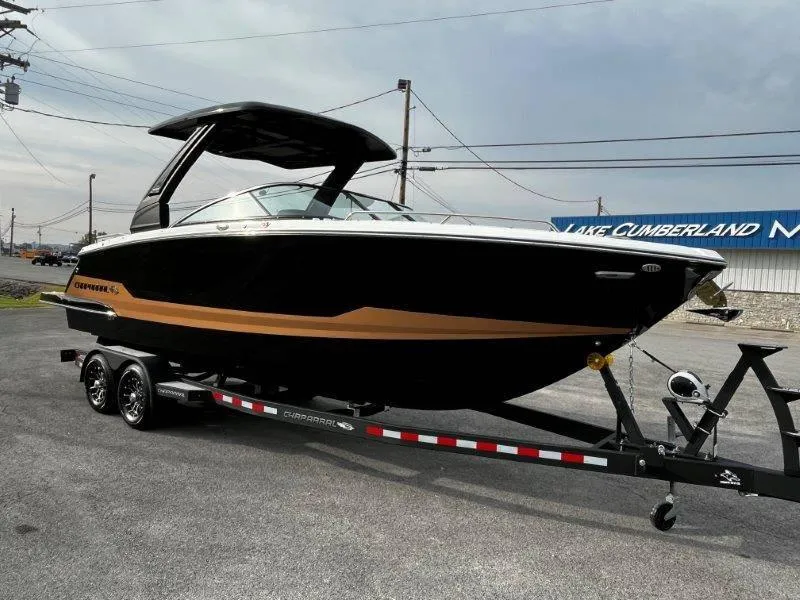 Slide: The Image of 2025 Chaparral 287 SSX boat on trailer, black and gold design, parked outdoors. - 34