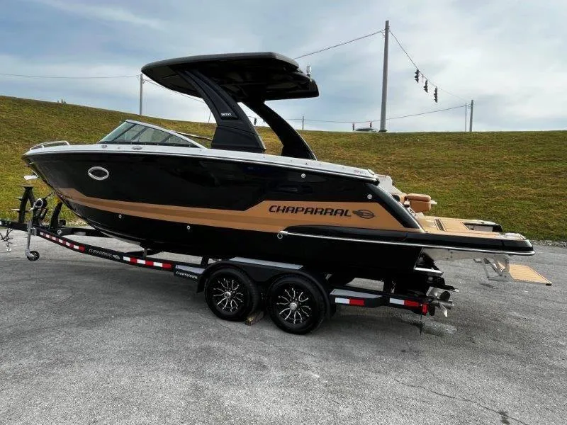 Slide: The Image of 2025 Chaparral 287 SSX boat on trailer, sleek black and gold design. - 38