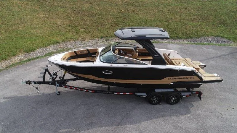 Slide: The Image of 2025 Chaparral 287 SSX boat on trailer, sleek design, black and tan color scheme. - 4