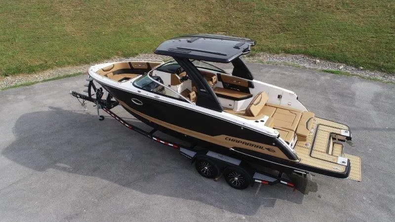Slide: The Image of 2025 Chaparral 287 SSX boat on trailer, sleek design, black and tan exterior. - 6