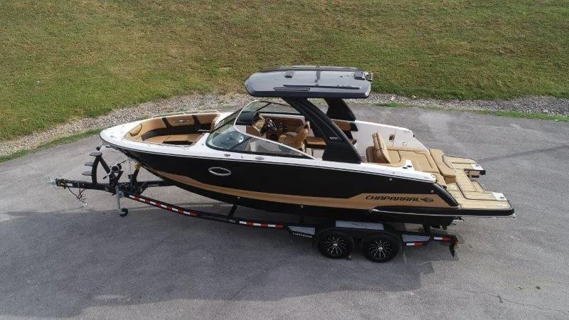 Slide: The Image of 2025 Chaparral 287 SSX boat on trailer, sleek design, black and tan exterior. - 7