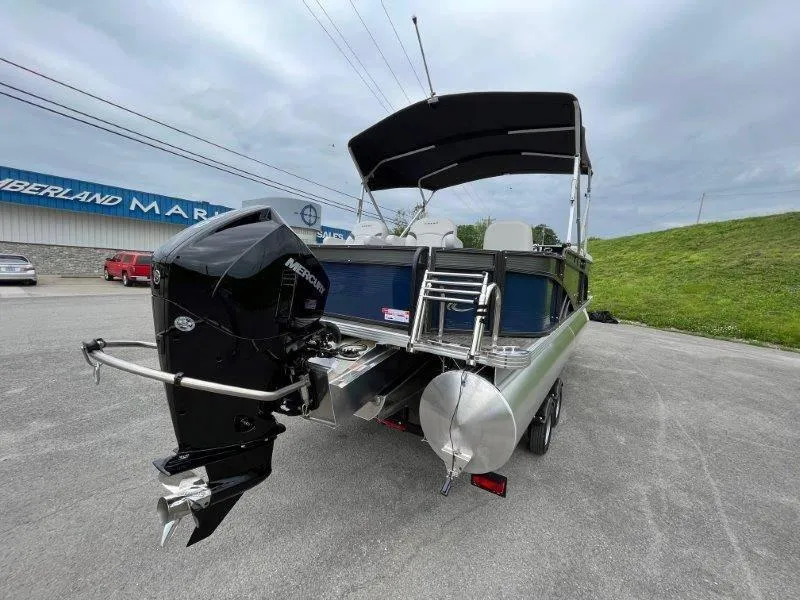 Slide: The Image of 2023 Crest Classic Fish 220 SF pontoon boat with Mercury outboard motor, parked outdoors. - 15