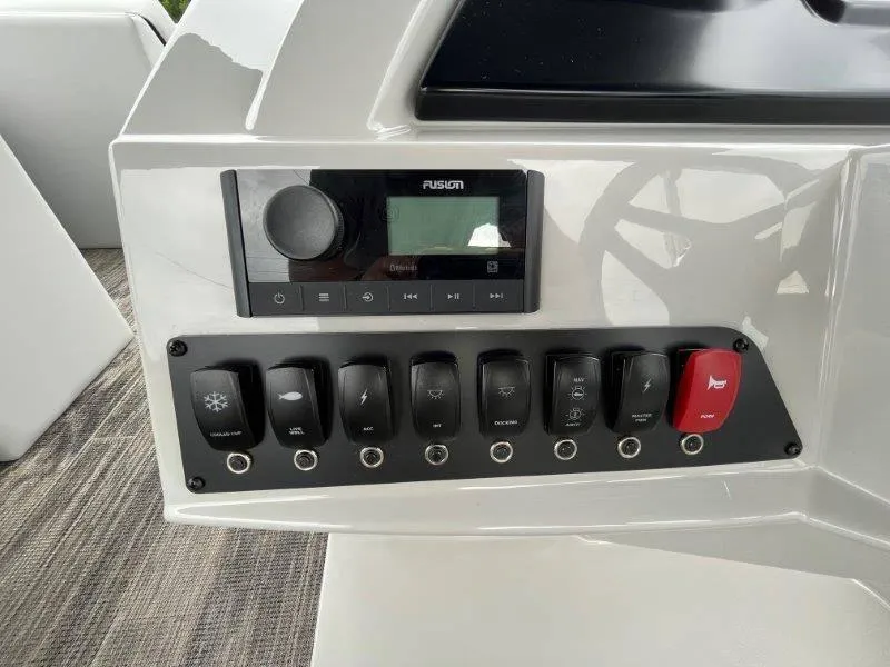 Slide: The Image of Control panel of 2023 Crest Classic Fish 220 SF boat with switches and audio system. - 17