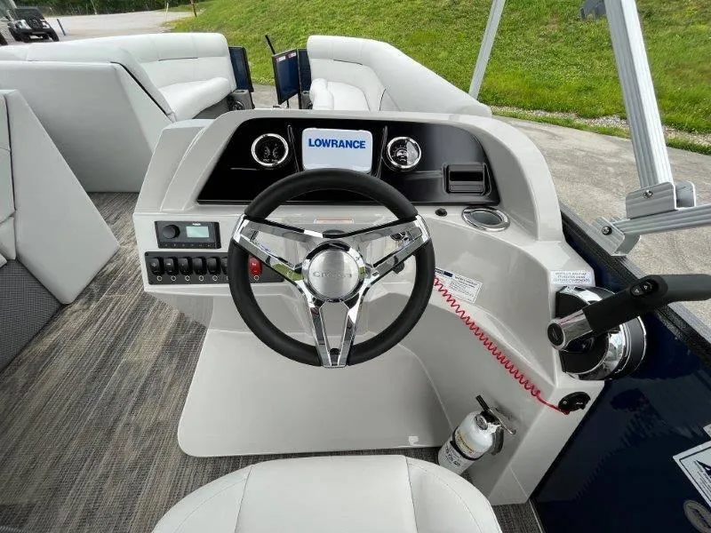 Slide: The Image of 2023 Crest Classic Fish 220 SF boat dashboard with steering wheel and Lowrance display. - 21