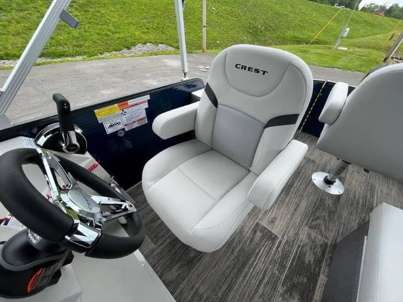 Slide: The Image of 2023 Crest Classic Fish 220 SF boat interior with steering wheel and comfortable seating. - 28