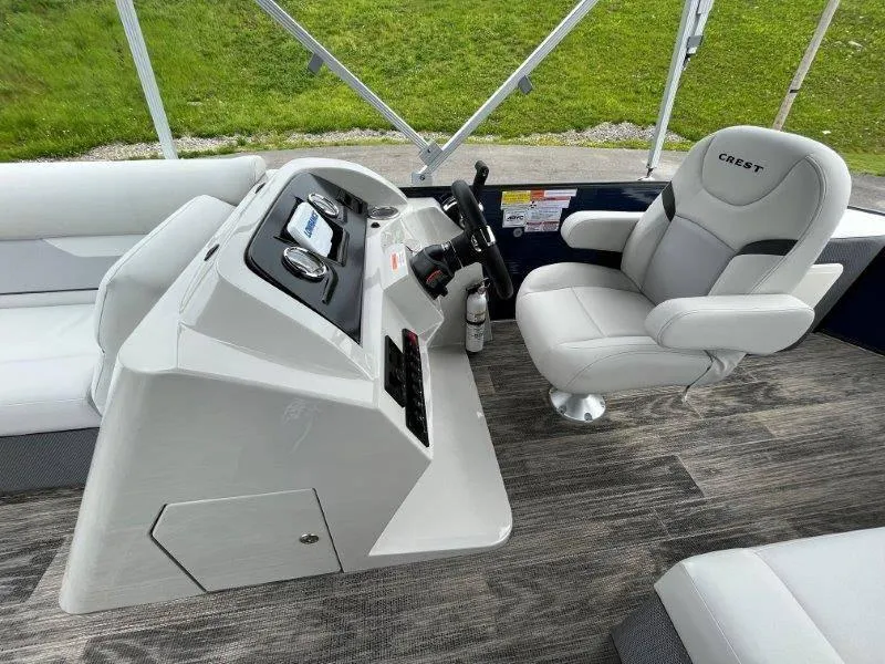 Slide: The Image of 2023 Crest Classic Fish 220 SF boat interior with captain's chair and control panel. - 31