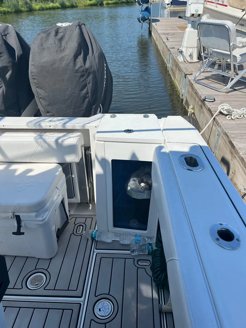 Slide: The Image of 2020 Blackfin 272 CC boat docked, featuring spacious deck and covered engines. - 10