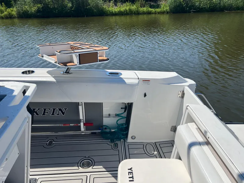 Slide: The Image of 2020 Blackfin 272 CC boat interior with fishing gear, Yeti cooler, and water view. - 12