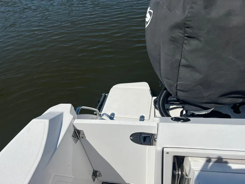Slide: The Image of 2020 Blackfin 272 CC boat stern view with covered engine on calm water. - 14