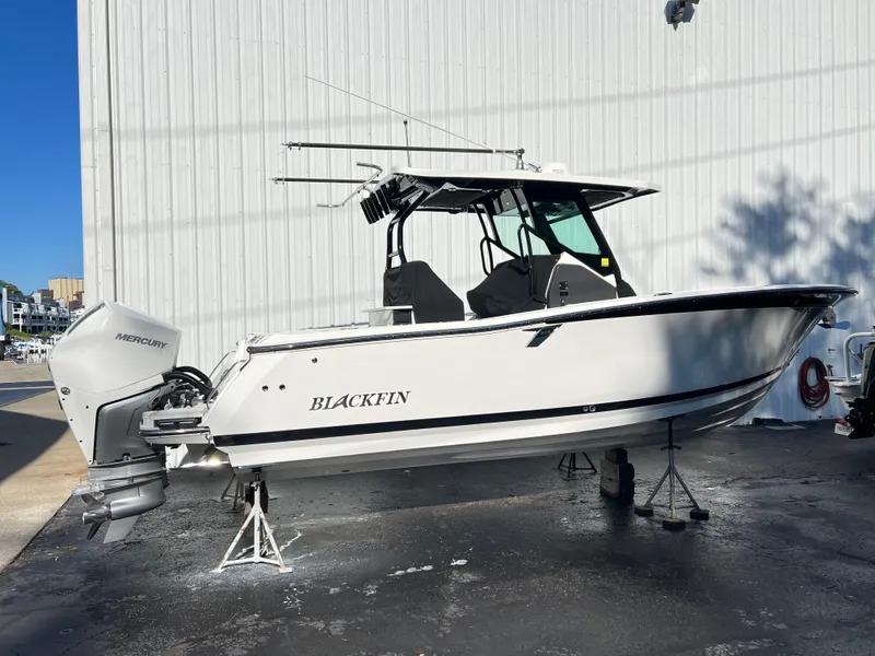Slide: The Image of 2020 Blackfin 272 CC boat with Mercury engine, displayed outdoors. - 2