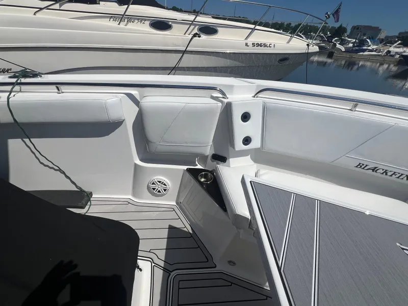 Slide: The Image of 2020 Blackfin 272 CC boat interior with seating and cup holder, docked at marina. - 21