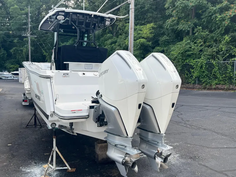 Slide: The Image of 2020 Blackfin 272 CC boat with dual Mercury outboard engines, parked outdoors. - 32