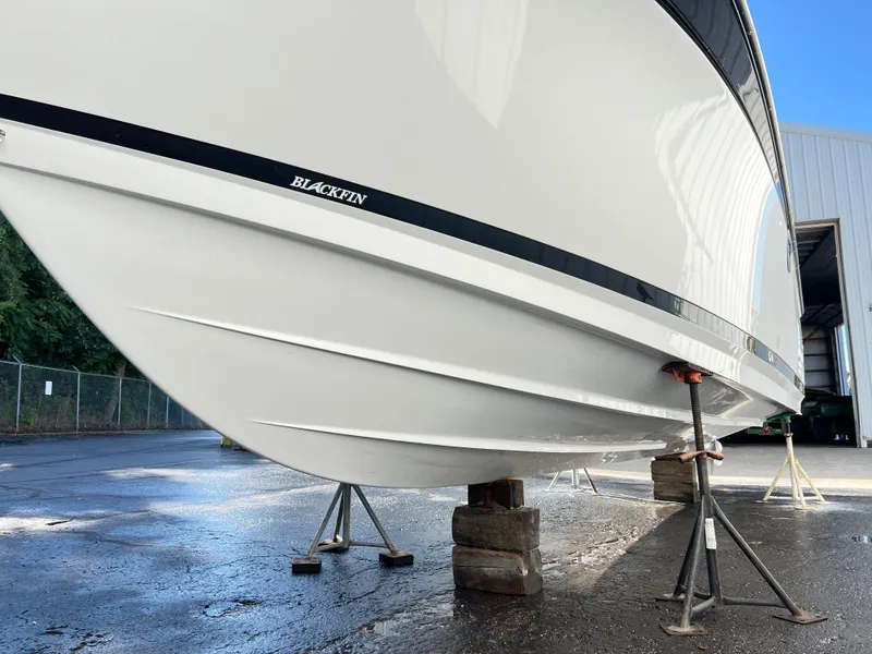Slide: The Image of 2020 Blackfin 272 CC boat on stands, side view in a marina setting. - 35