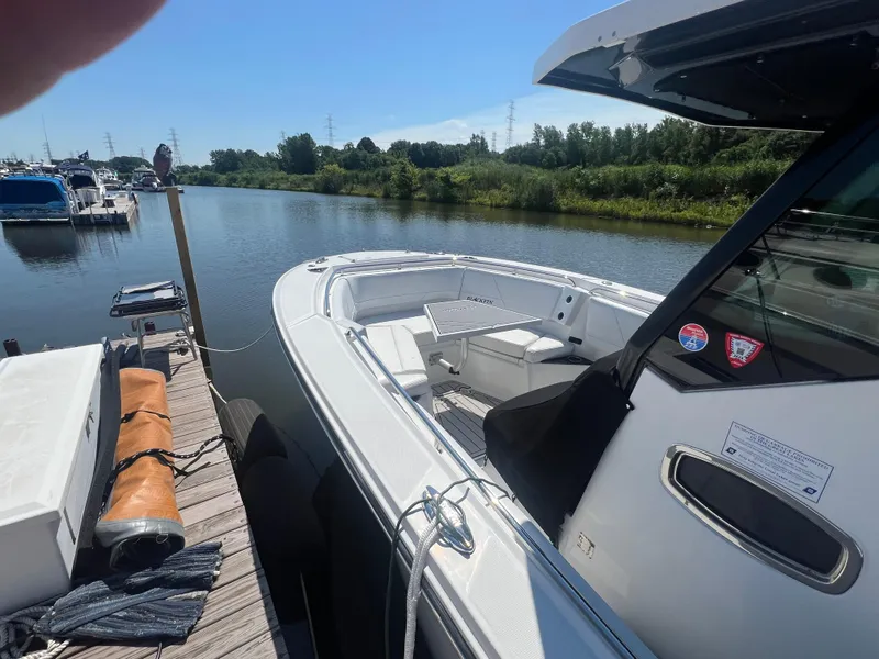 Slide: The Image of 2020 Blackfin 272 CC boat docked by a serene river. - 7
