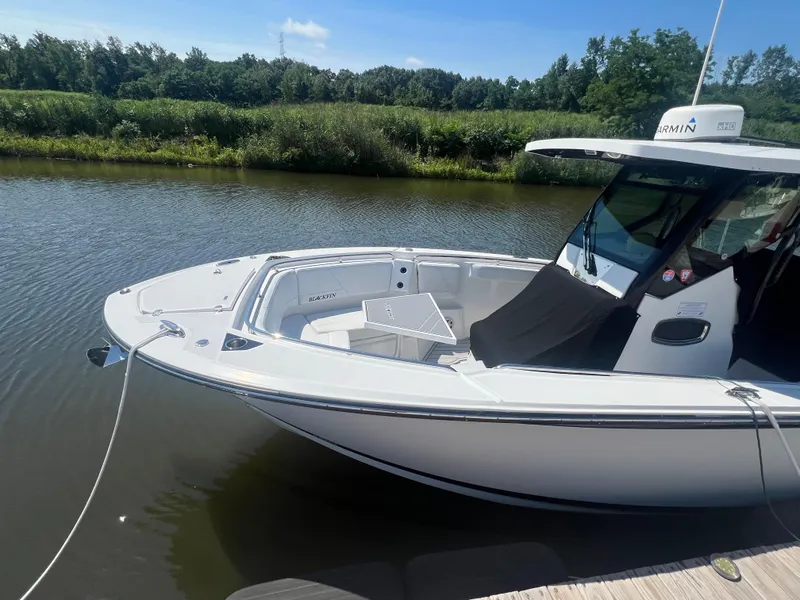 Slide: The Image of 2020 Blackfin 272 CC boat docked on a calm river. - 9