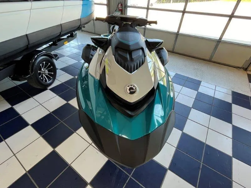 Slide: The Image of 2024 Sea-Doo GTI SE 130 iBR Tech jet ski in showroom, teal and black design. - 18