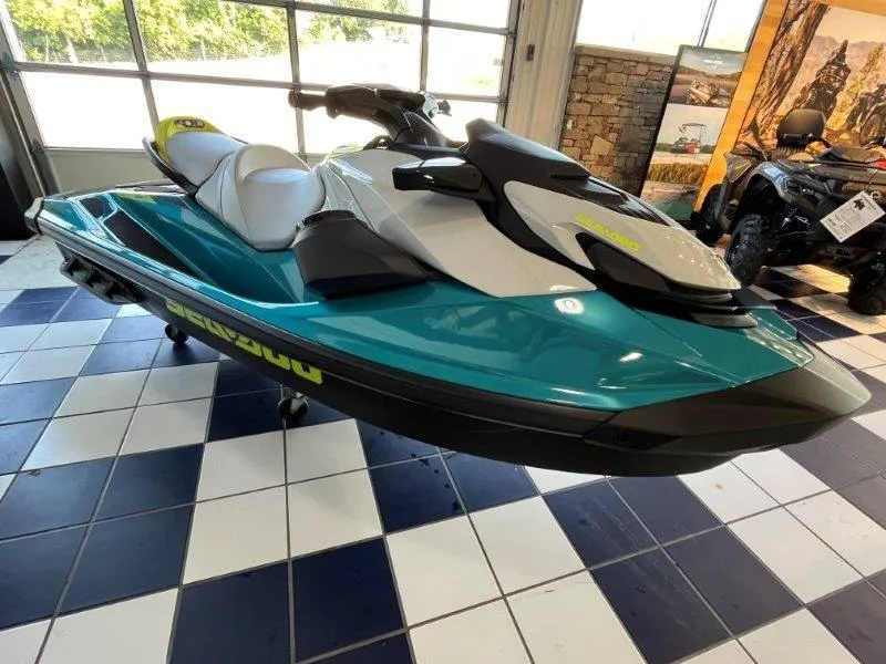 Slide: The Image of 2024 Sea-Doo GTI SE 130 iBR jet ski in showroom, teal and white design. - 23