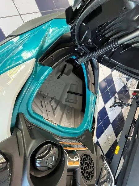 Slide: The Image of 2024 Sea-Doo GTI SE 130 iBR storage compartment, teal and black design, open view. - 24