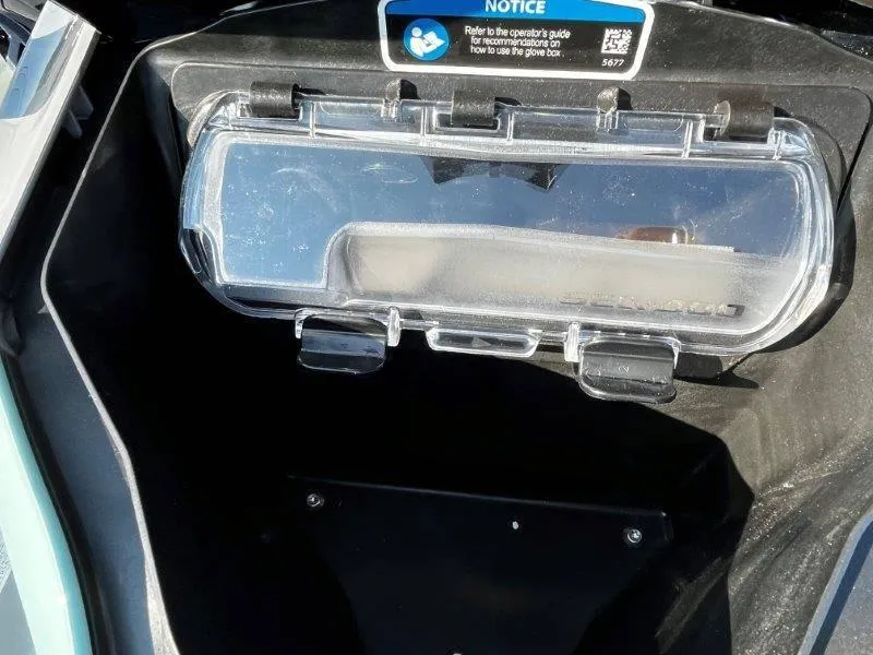Slide: The Image of 2024 Sea-Doo GTI SE 130 glove box interior with clear cover and notice label. - 31