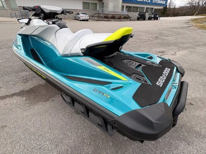 Slide: The Image of 2024 Sea-Doo GTI SE 170 IBR jet ski in vibrant blue, parked outdoors. - 21