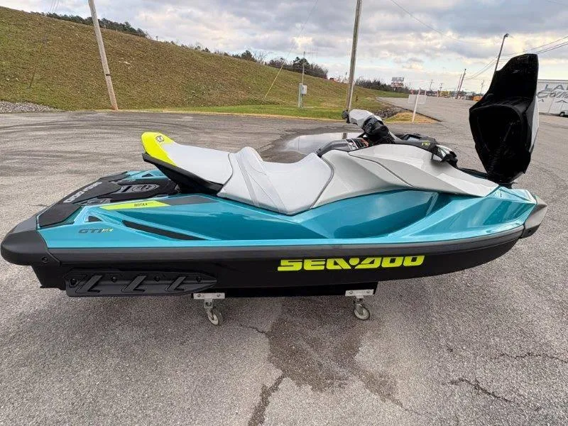 Slide: The Image of 2024 Sea-Doo GTI SE 170 IBR jet ski, teal and black, parked on pavement. - 9