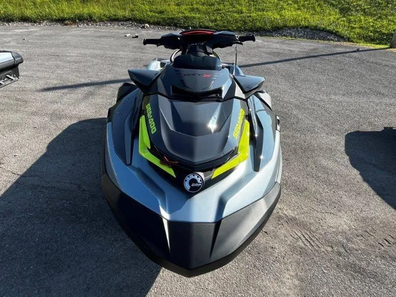 Slide: The Image of 2024 Sea-Doo RXT-X 325 in Ice Metal and Manta Green on pavement. - 16
