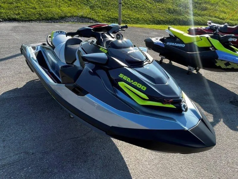 Slide: The Image of 2024 Sea-Doo RXT-X 325 in Ice Metal and Manta Green on pavement. - 18