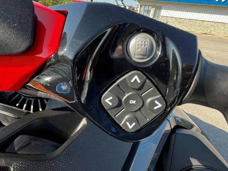 Slide: The Image of Close-up of 2024 Sea-Doo RXT-X 325 handlebar controls, featuring directional buttons. - 19