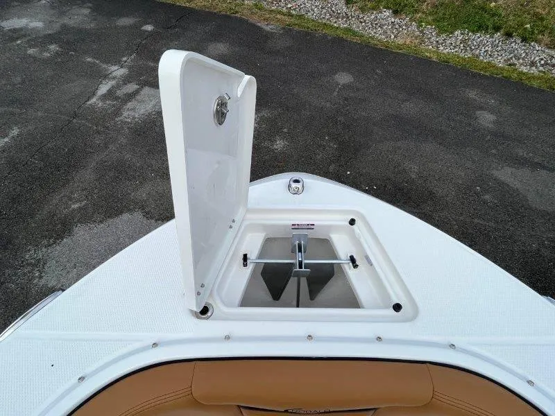 Slide: The Image of 2024 Robalo R207 boat anchor compartment with open hatch on deck. - 21