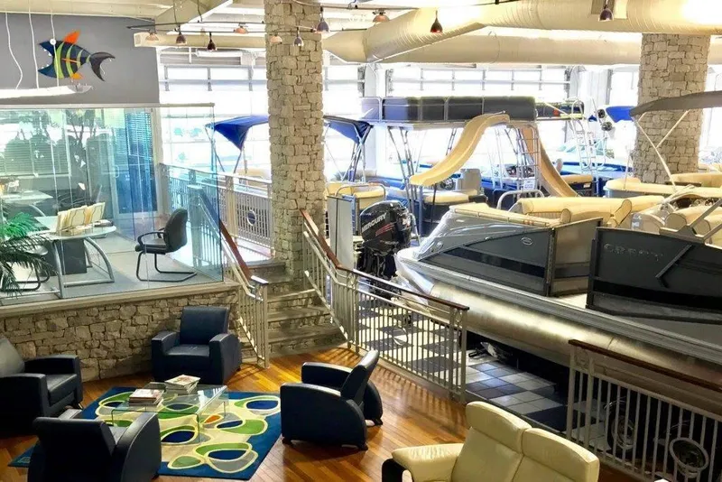 Slide: The Image of Boat showroom with 2024 Robalo R207, modern seating, and vibrant decor. - 23