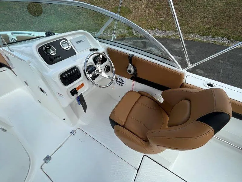Slide: The Image of 2024 Robalo R207 boat cockpit with brown seat and modern steering console. - 25
