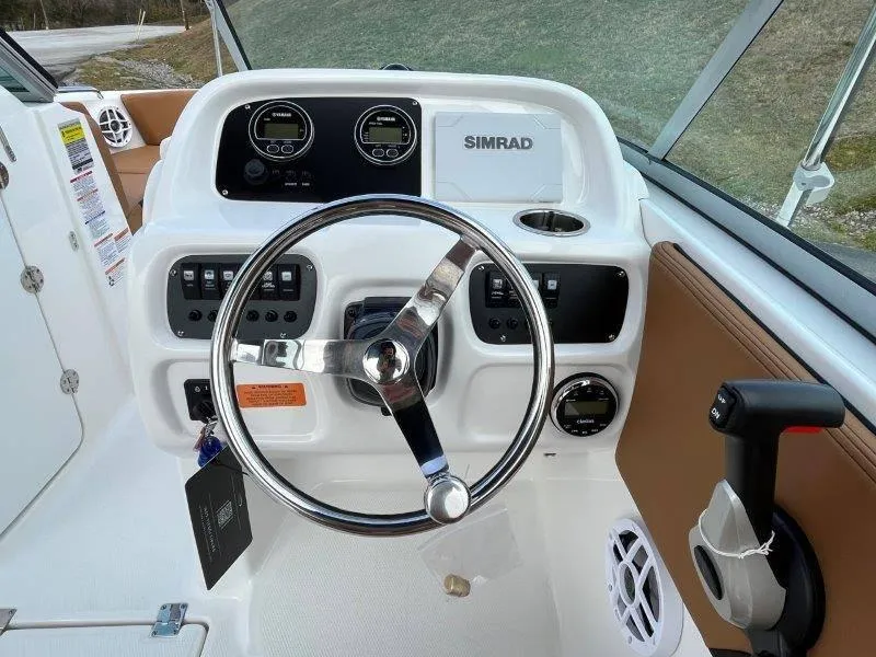 Slide: The Image of 2024 Robalo R207 boat dashboard with steering wheel and Simrad electronics. - 27
