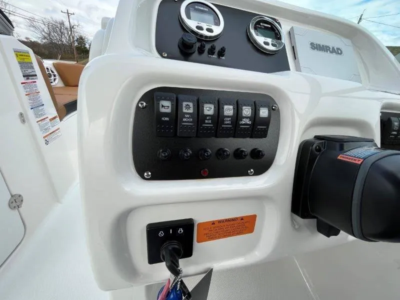 Slide: The Image of 2024 Robalo R207 boat dashboard with control panel and Simrad display. - 30