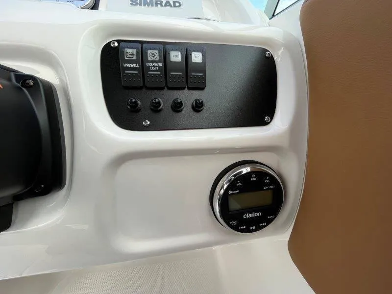 Slide: The Image of 2024 Robalo R207 boat dashboard with control panel and Clarion audio system. - 31