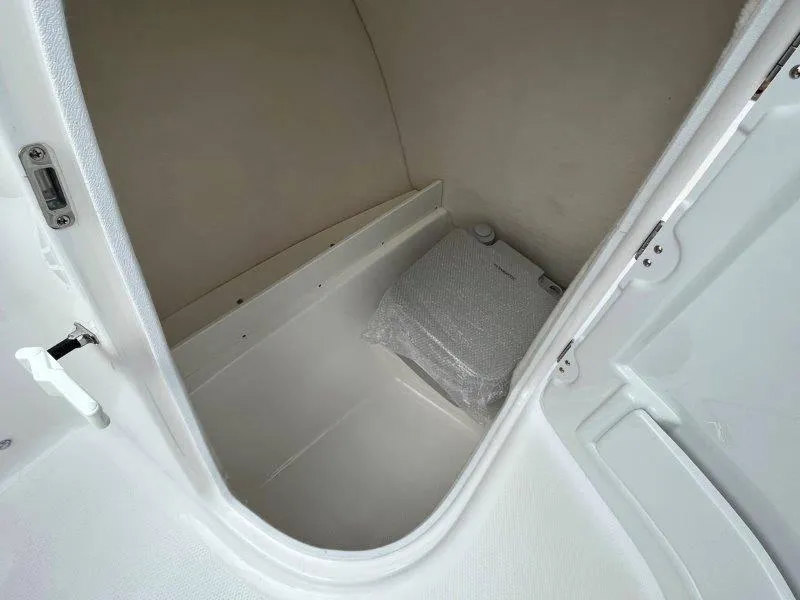 Slide: The Image of 2024 Robalo R207 boat storage compartment with white interior. - 41