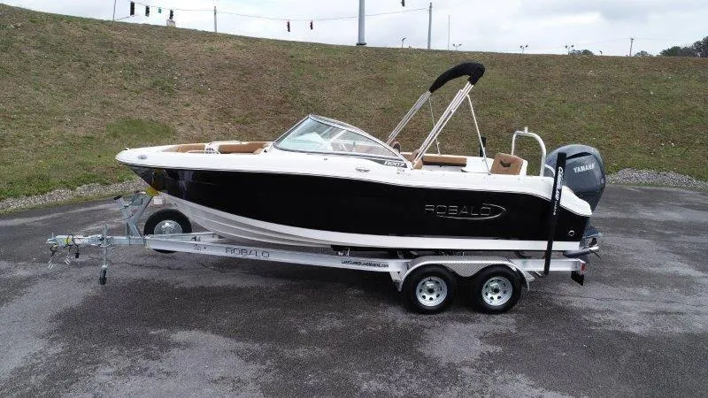 Slide: The Image of 2024 Robalo R207 boat on trailer, black and white design, parked outdoors. - 5