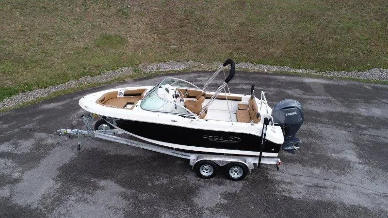 Slide: The Image of 2024 Robalo R207 boat on trailer, black and white design, parked on asphalt. - 8