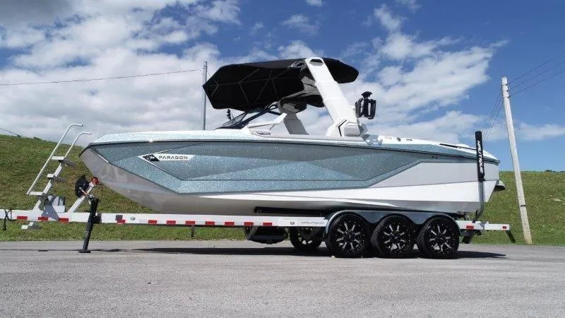 Slide: The Image of 2020 Nautique Paragon P25 boat on trailer under blue sky. - 10